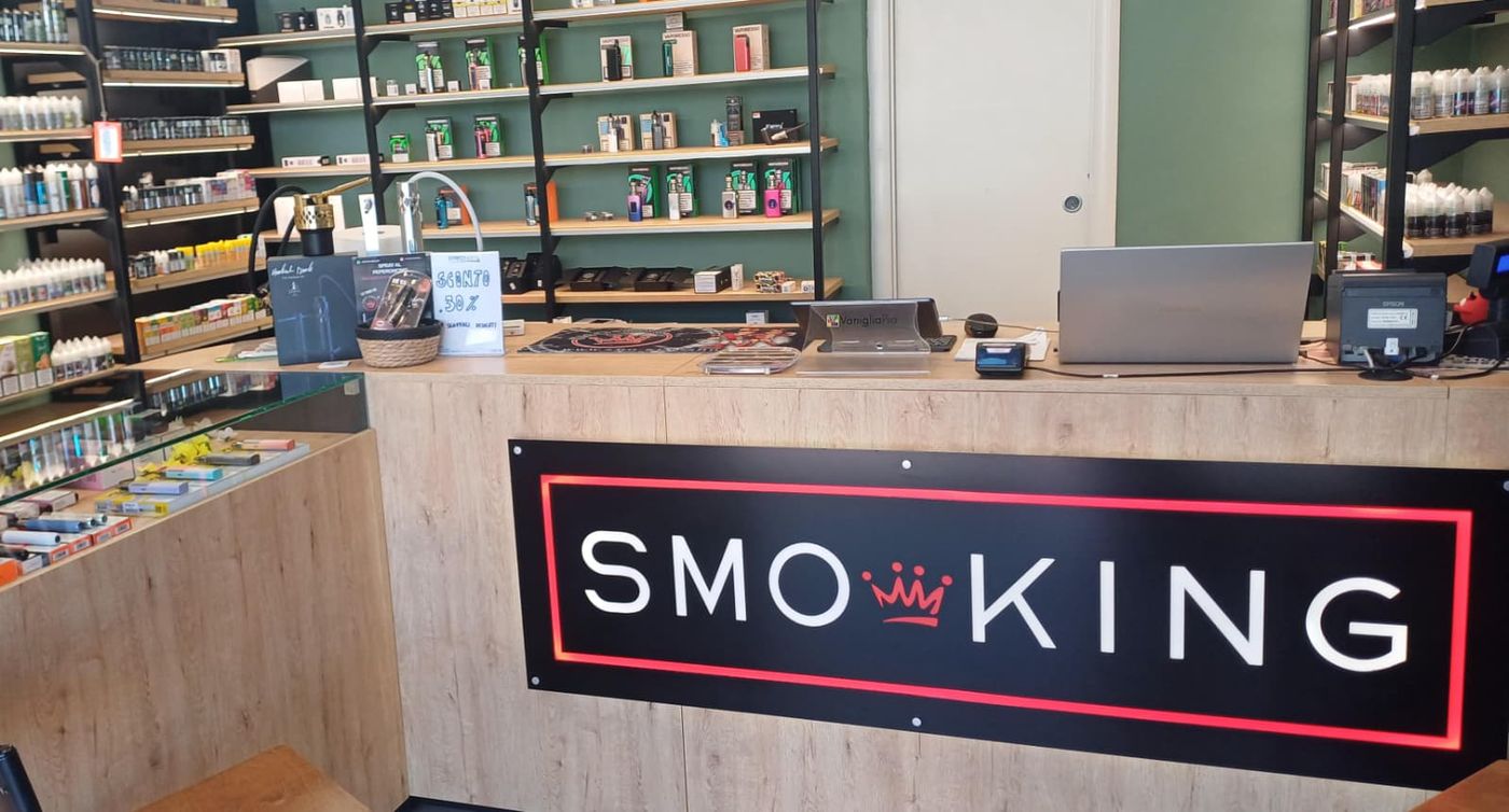 Bancone del negozio Smo-King di Casetta Mattei con logo Smo-King e scaffali di liquidi alle spalle