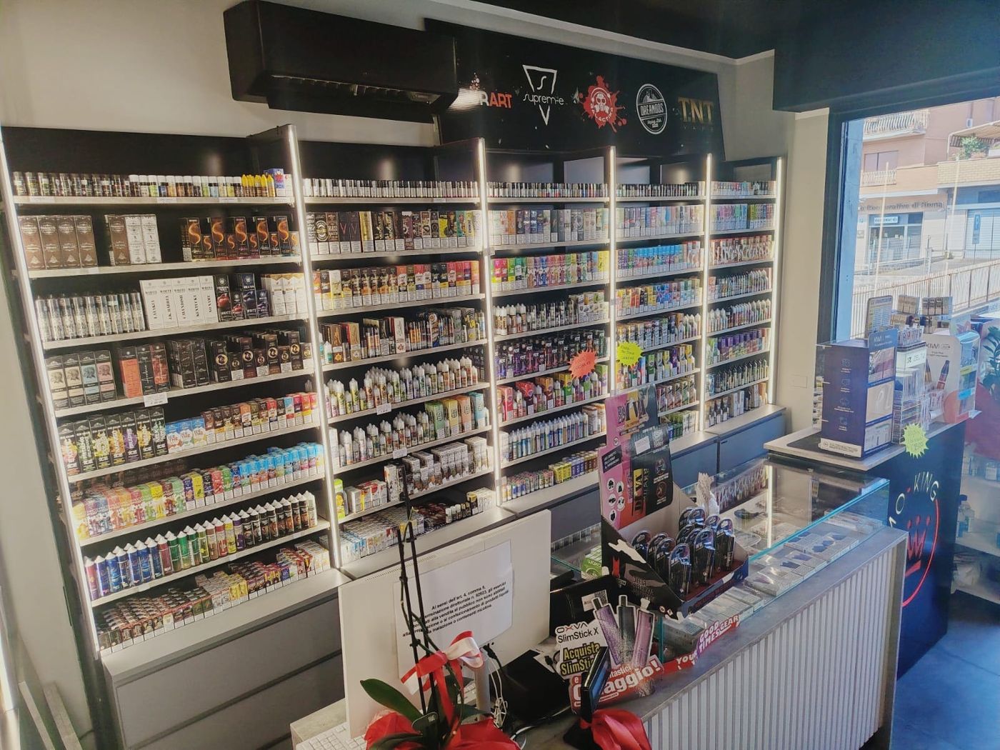 Parete di liquidi e aromi del negozio Smo-King di Via Prenestina 1206, con i marchi VaporArt, Suprem-e, Dreamods e TNT Vape