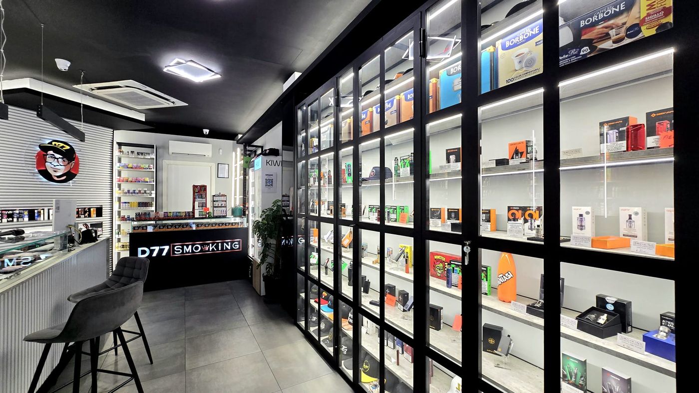 Vetrine illuminate del negozio D77 Smo-King di Viale Marconi con kit, atomizzatori e accessori per sigaretta elettronica