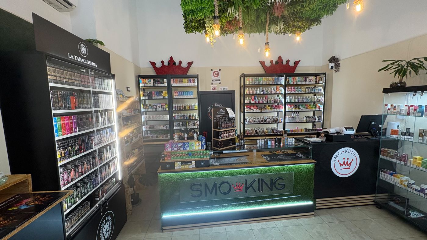 Interno del negozio Smo-King di Messina: bancone con logo Smo-King, scaffali di liquidi e vetrina degli estratti di tabacco