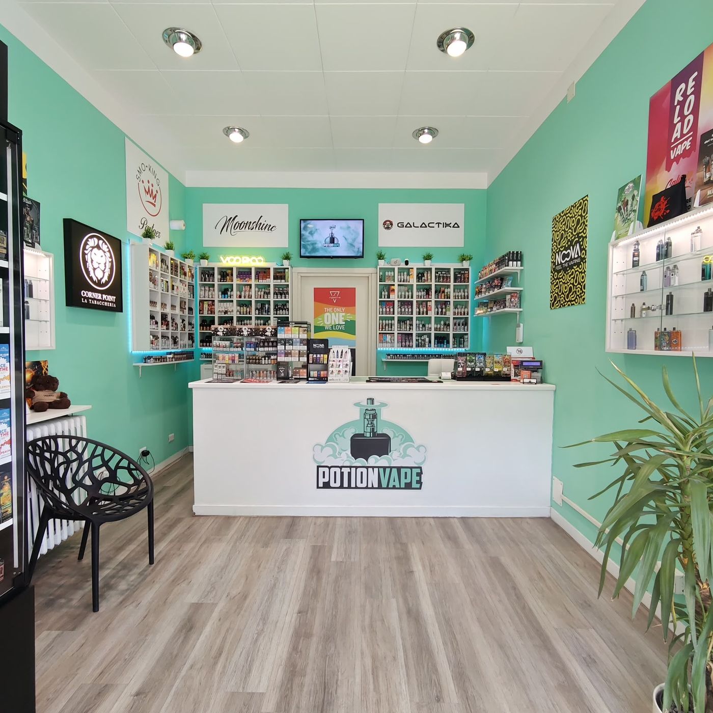 Interno del negozio PotionVape di Via Imbonati a Milano, con bancone bianco e pareti verdi con espositori di liquidi e dispositivi