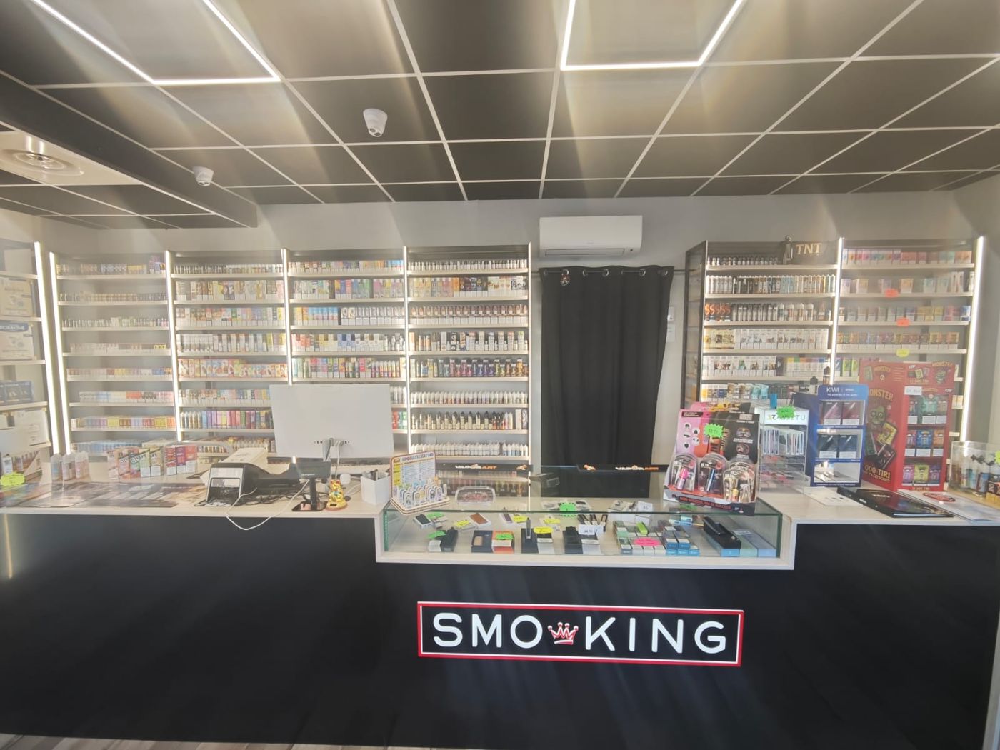 Bancone del negozio Smo-King di Nettuno con vetrina dei dispositivi e scaffali di aromi e liquidi