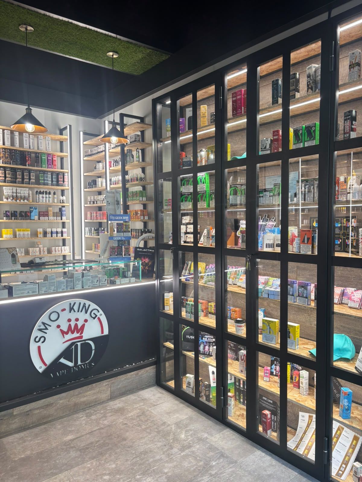 Vetrine a tutta altezza del negozio Smo-King Vape Domus con liquidi, kit e accessori
