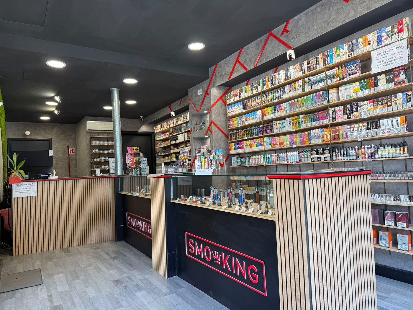 Interno del negozio Smo-King di Sabaudia con bancone, logo Smo-King e scaffali di liquidi e dispositivi