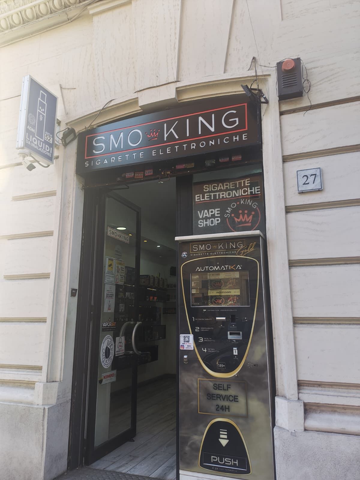 Ingresso del negozio Smo-King Gold in Via Aosta 27 a Roma, zona San Giovanni, con insegna Smo-King e distributore automatico