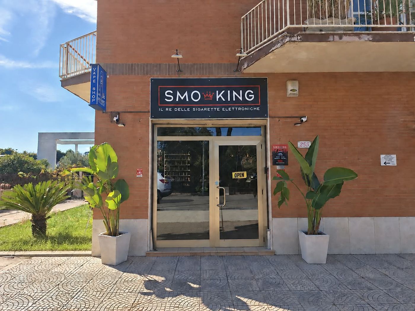 Ingresso del negozio Smo-King Terracina Badino in Via Badino 255, con insegna blu Smo-King il re delle sigarette elettroniche