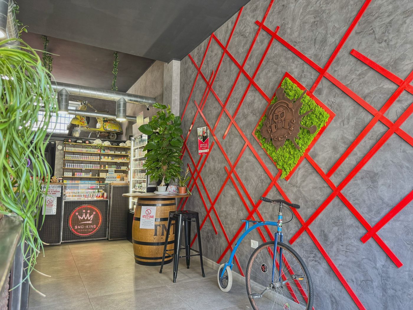 Angolo del negozio Smo-King di Terracina con botte, sgabelli e decorazione a righe rosse sul muro