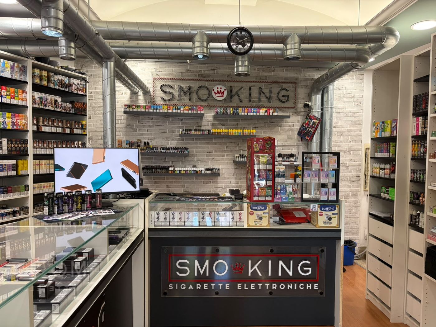 Bancone del negozio Smo-King di Piazza Irnerio con logo Smo-King e scaffali di liquidi e dispositivi