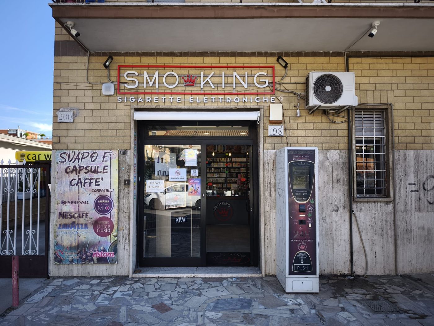 Ingresso del negozio Smo-King di Via di Torrenova 198 a Roma, zona Torre Angela, con insegna Smo-King Sigarette Elettroniche e distributore automatico 24h